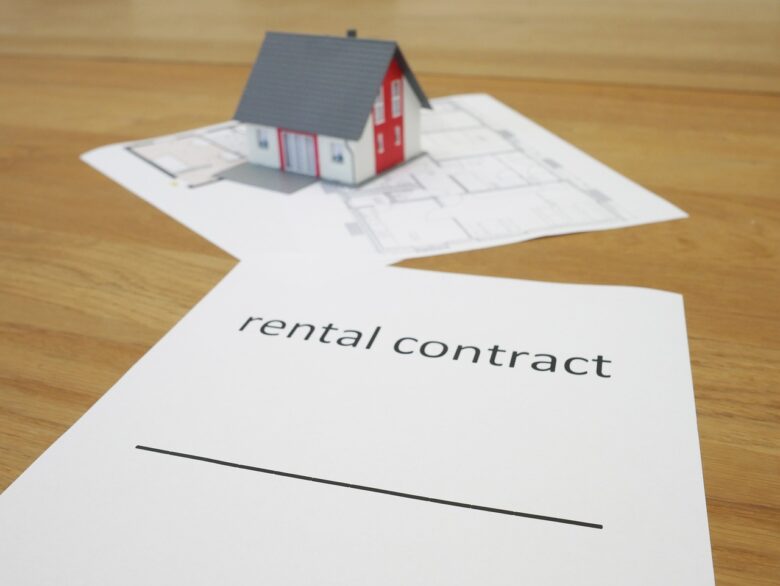 家の模型と「rental contract」と書かれた書類