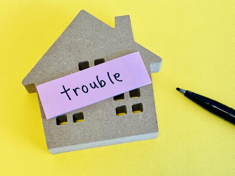 家の模型に「trouble」と書かれた付箋とペン