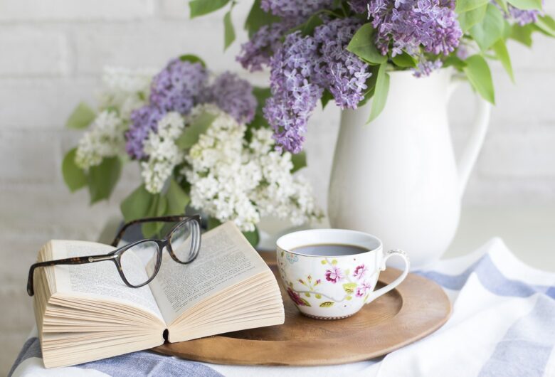 テーブルの上の花瓶、眼鏡、本、コーヒー