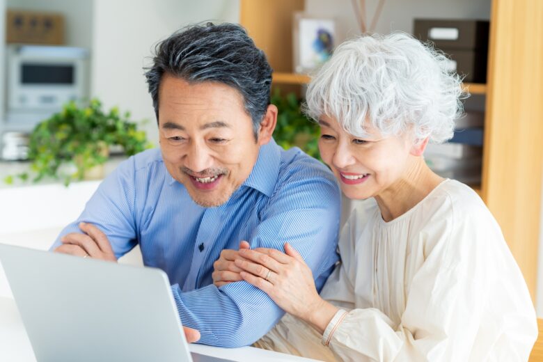 笑顔でPCを操作するシニア夫婦