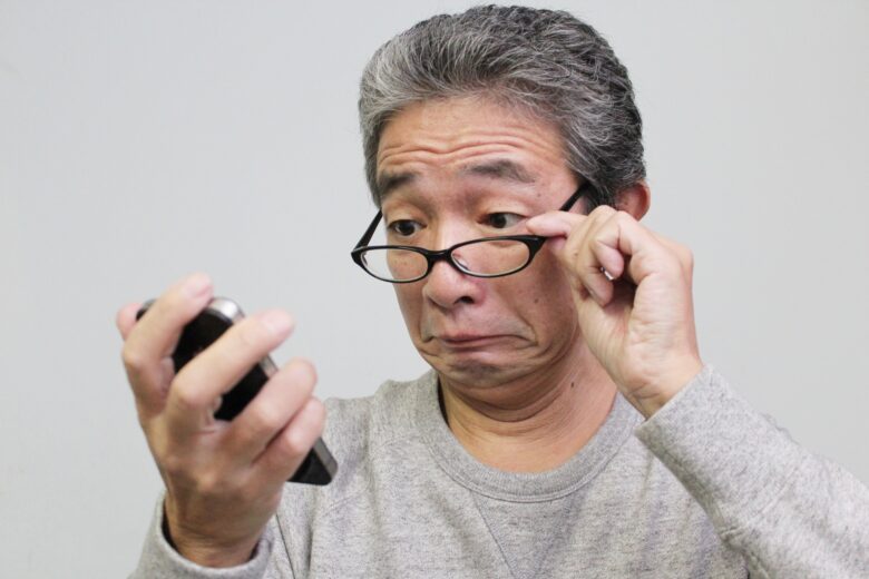 スマホを覗き込むシニア男性